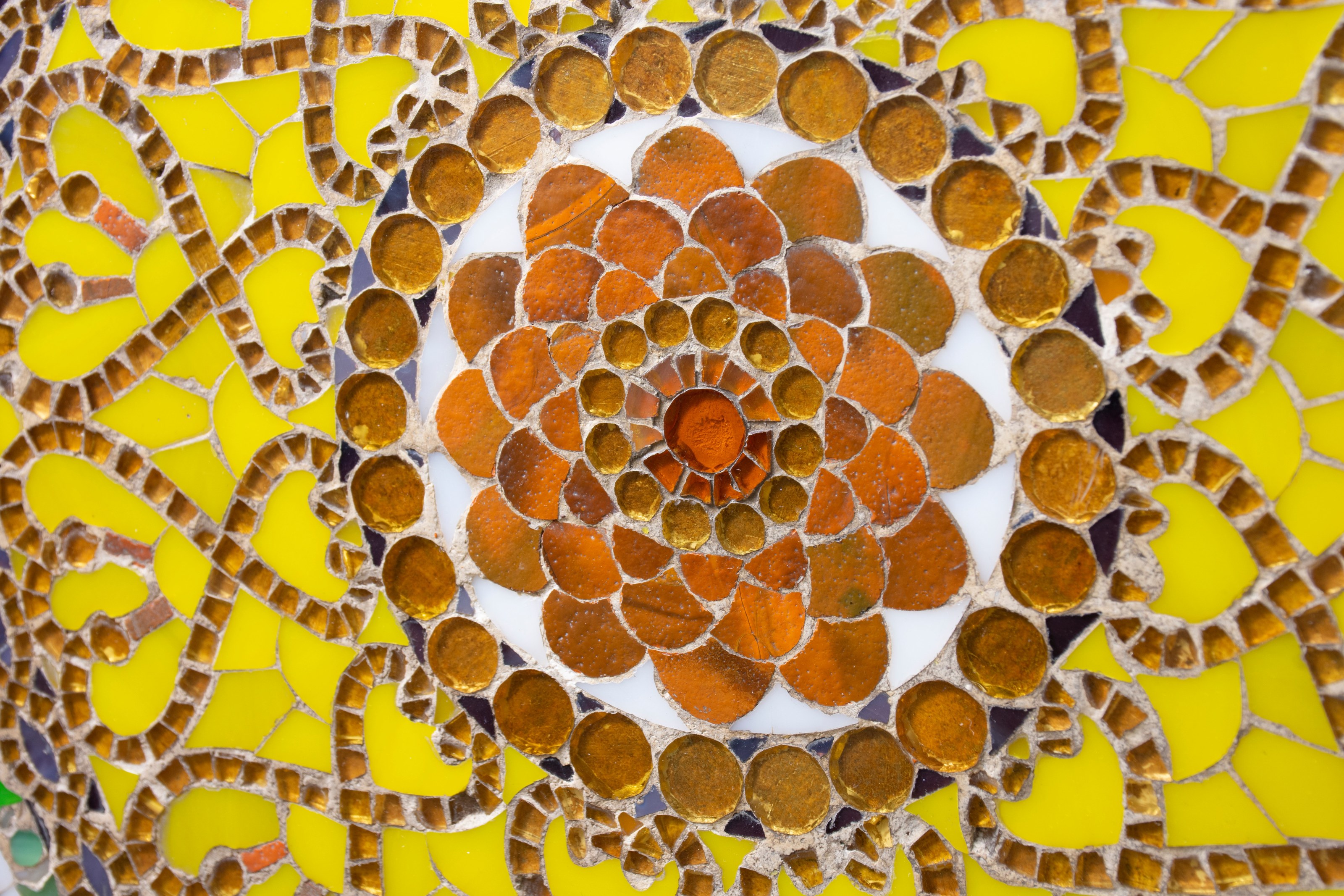 the center of the tiffany favrile glass clock panel, showing the depth of the clear foil backed glass contrasted with the more opaque white and yellow glass in the sunburst motif.