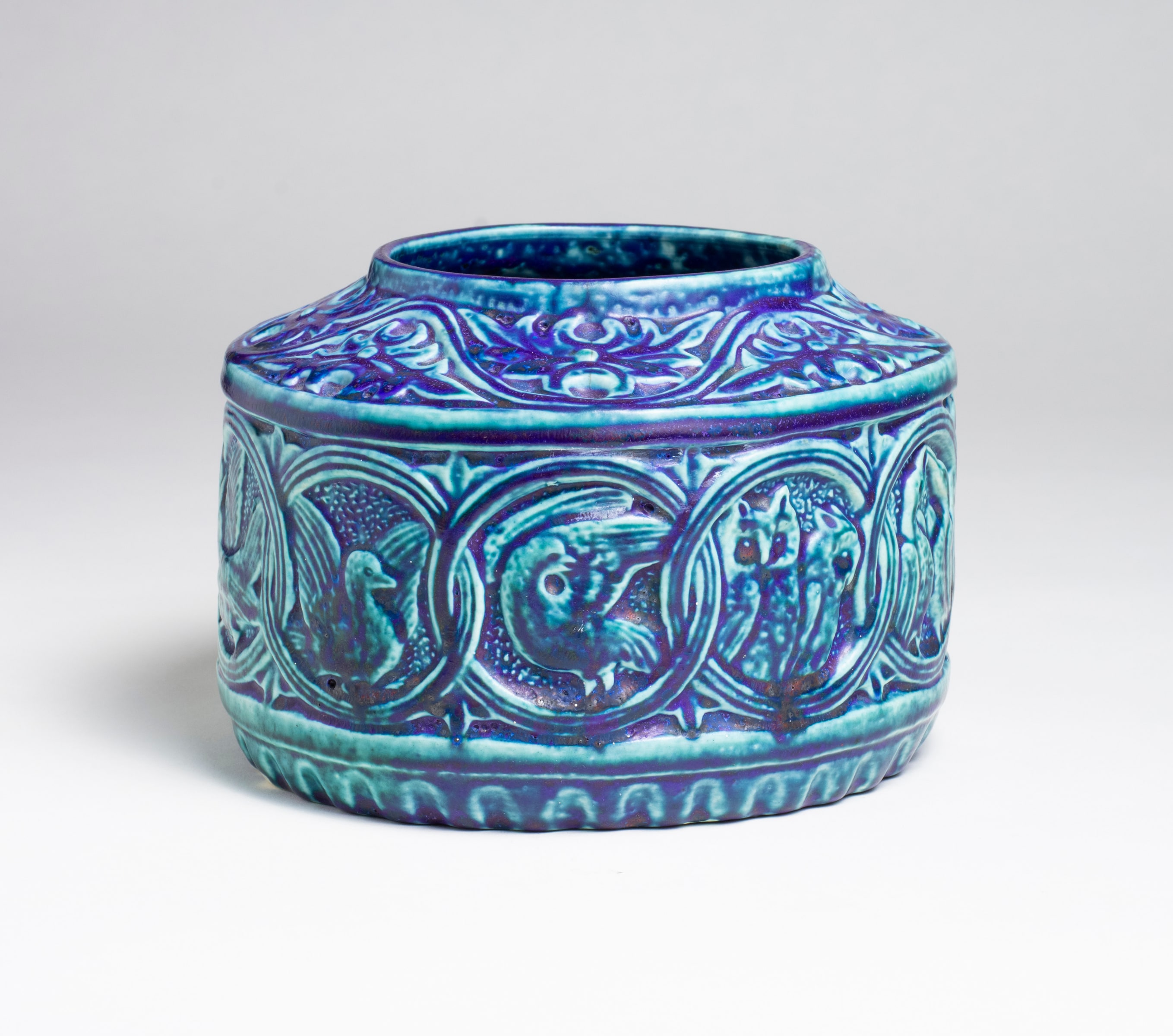 a blue glazed tiffany favrile pottery bowl with celtic inspired interlace motif each circle enclosing a unique depiction of a bird of group of birds