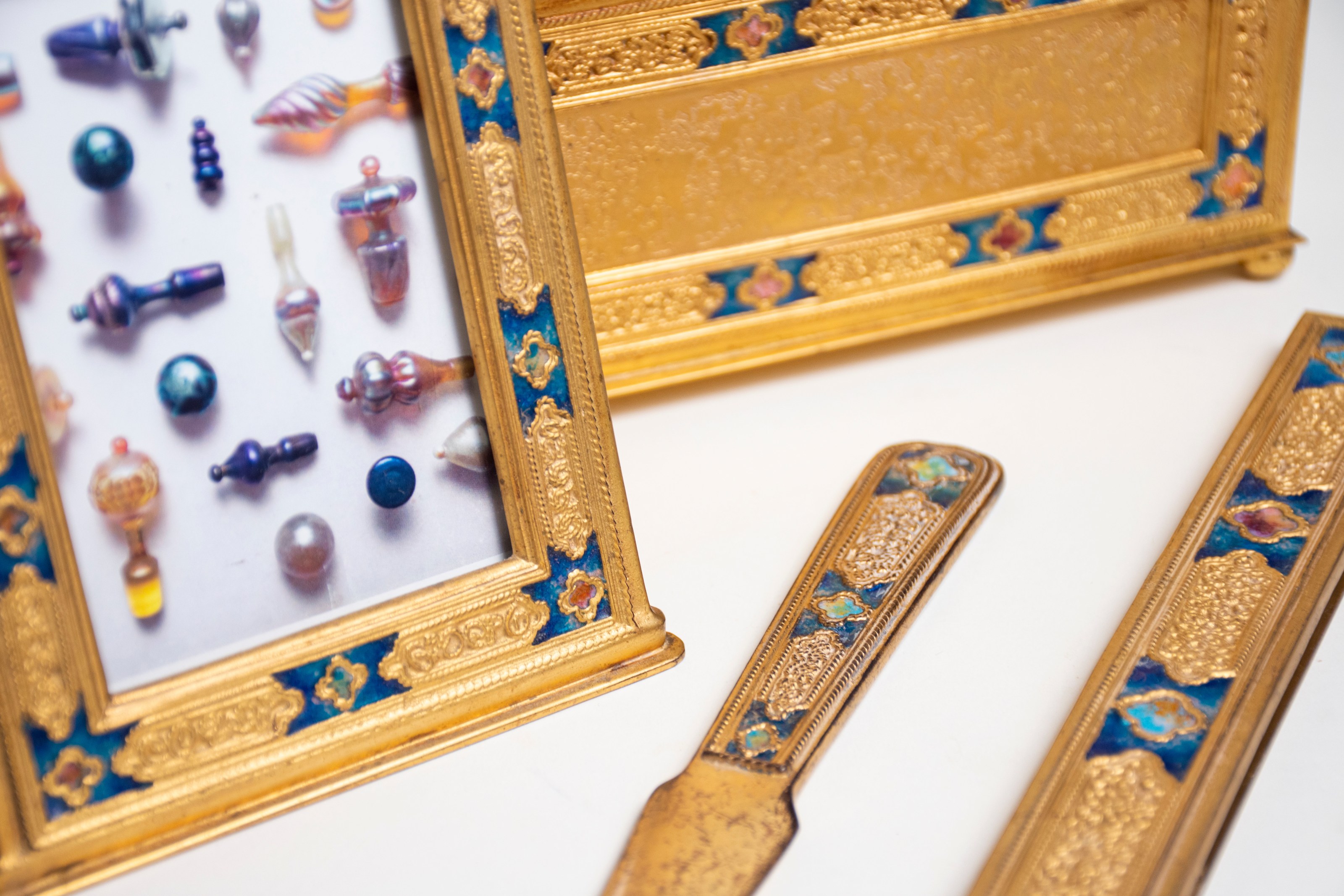 detail of the delicate twisted wirework and inset enamel in jewel tones like sapphire blue and emerald green on the louis c. tiffany furnaces enameled desk set