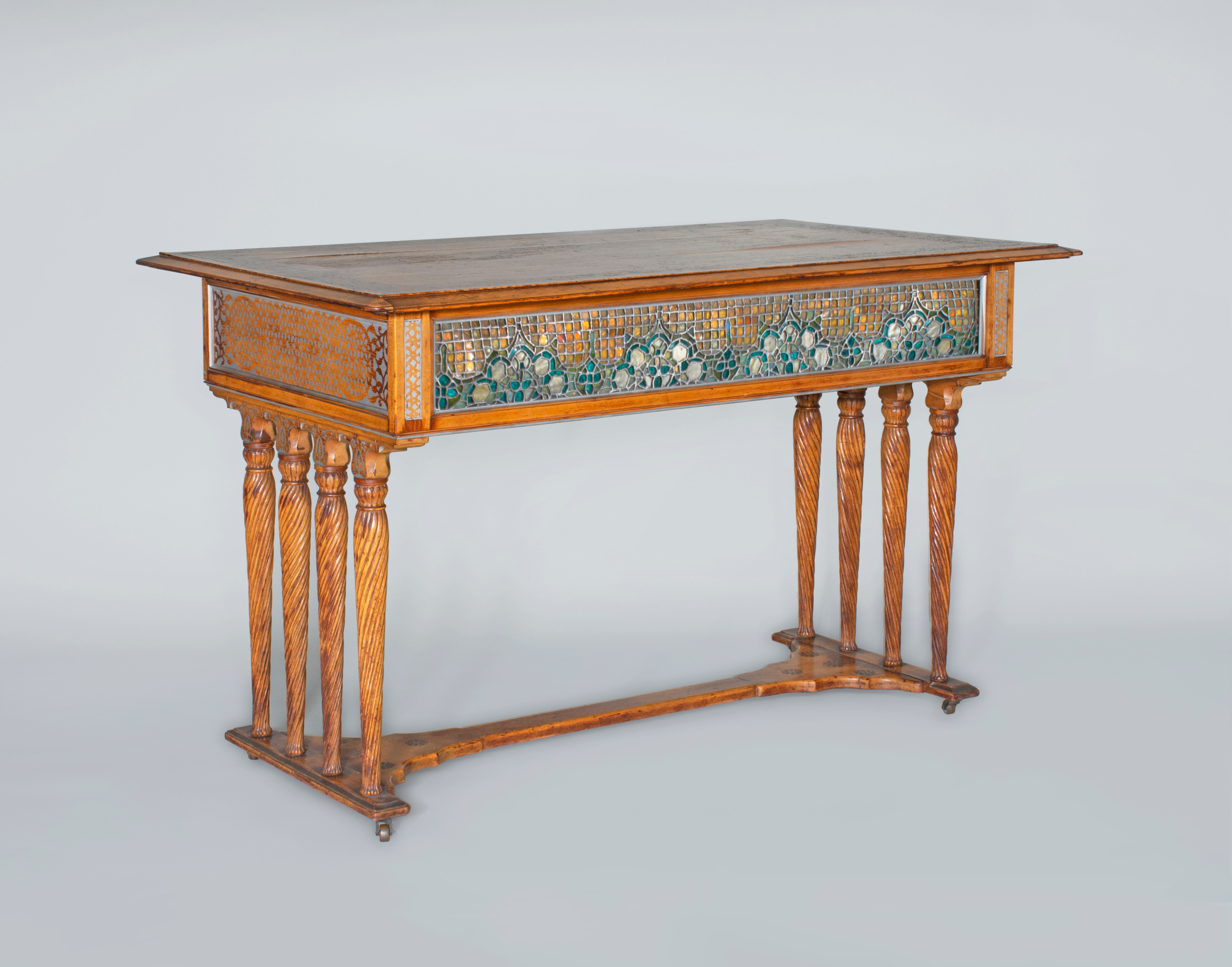 an early piece of furniture by louis comfort tiffany, very rare, aesthetic movement style incorporating stylistic influence and techniques. turned wooden legs, with extremely rare horizontal inset leaded glass panels in blue and silver