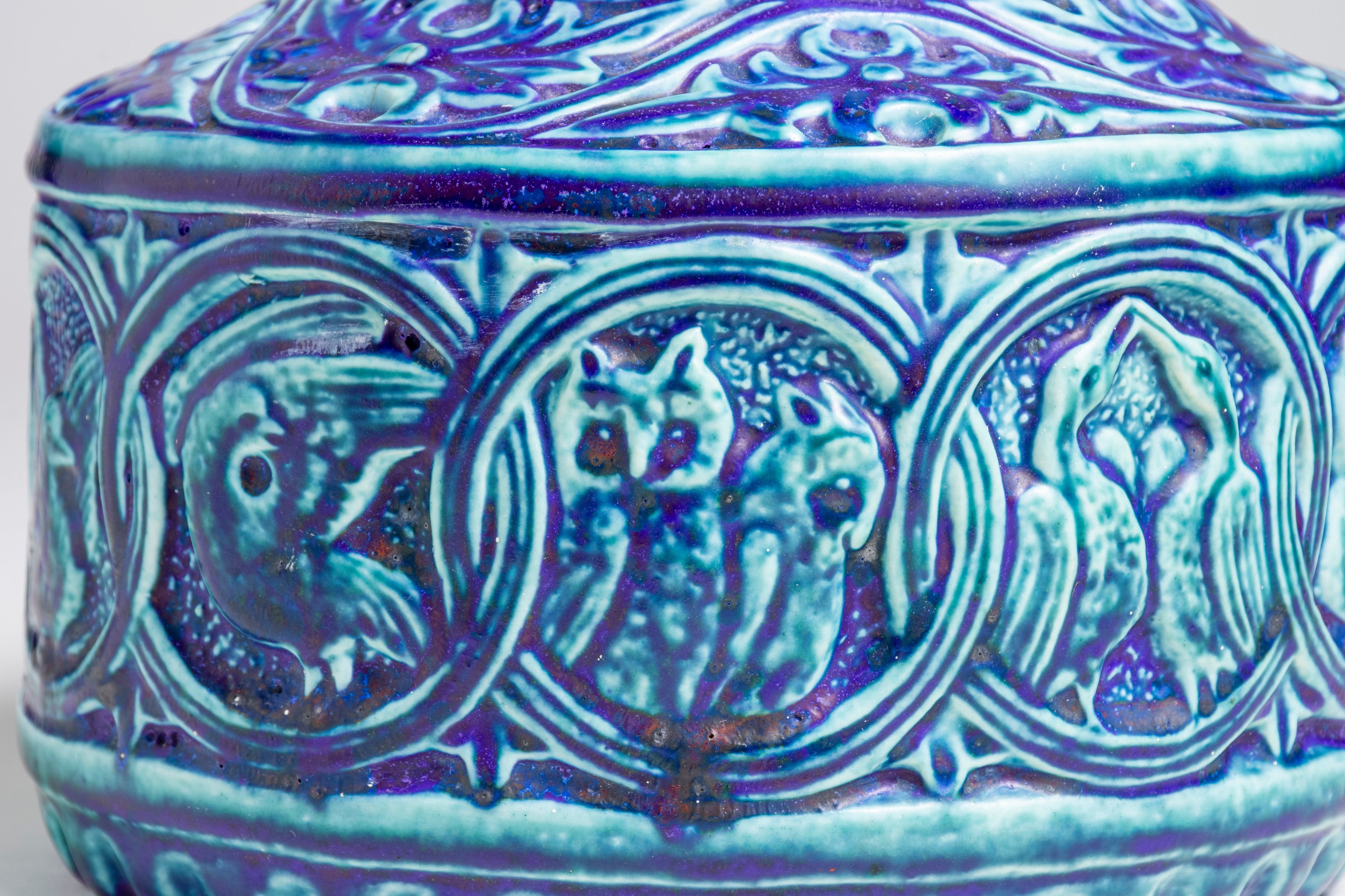 a detail of the tiffany favrile pottery bowl with celtic interlace inspired decoration showing some of the artistic handling of the bird motifs