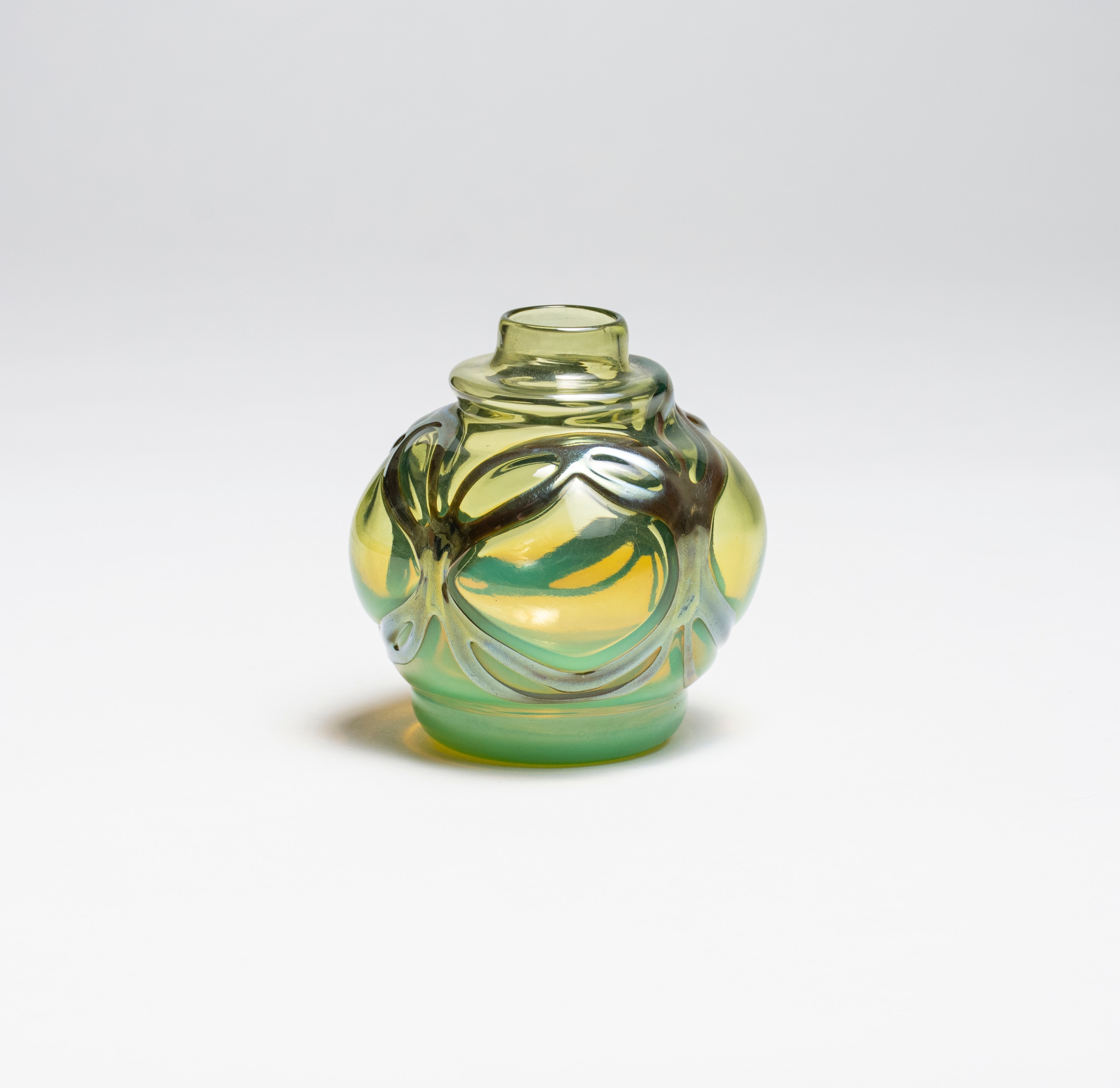 an early piece of blown tiffany favrile glass, a smallish cabinet vase in a slightly neon yellow-ish green tone, with a different layer of silvery glass applied to the surface as if metalwork.