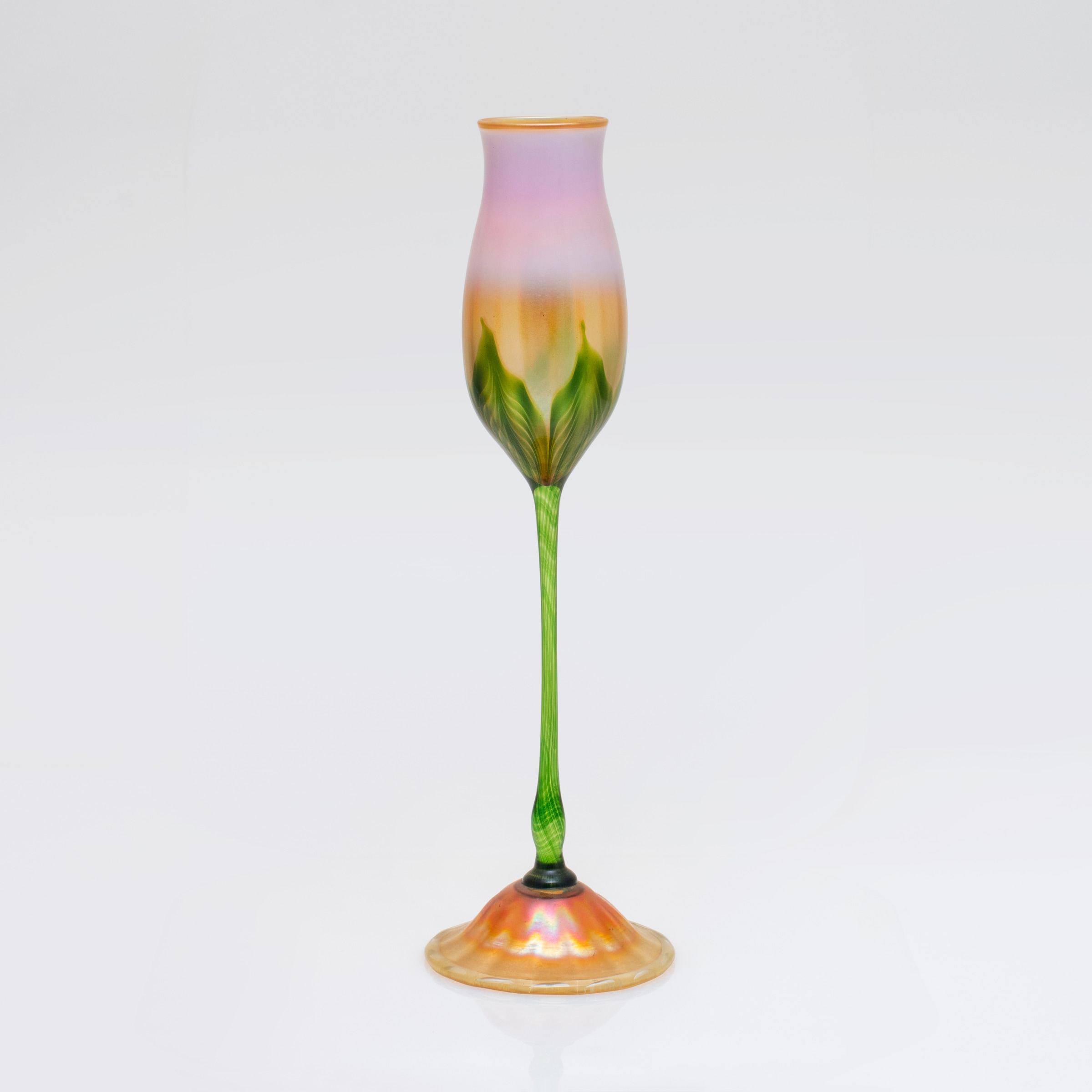 a tiffany favrile glass flower form vase with pinkish flower cup decorated with green stems and gold iridescent foot