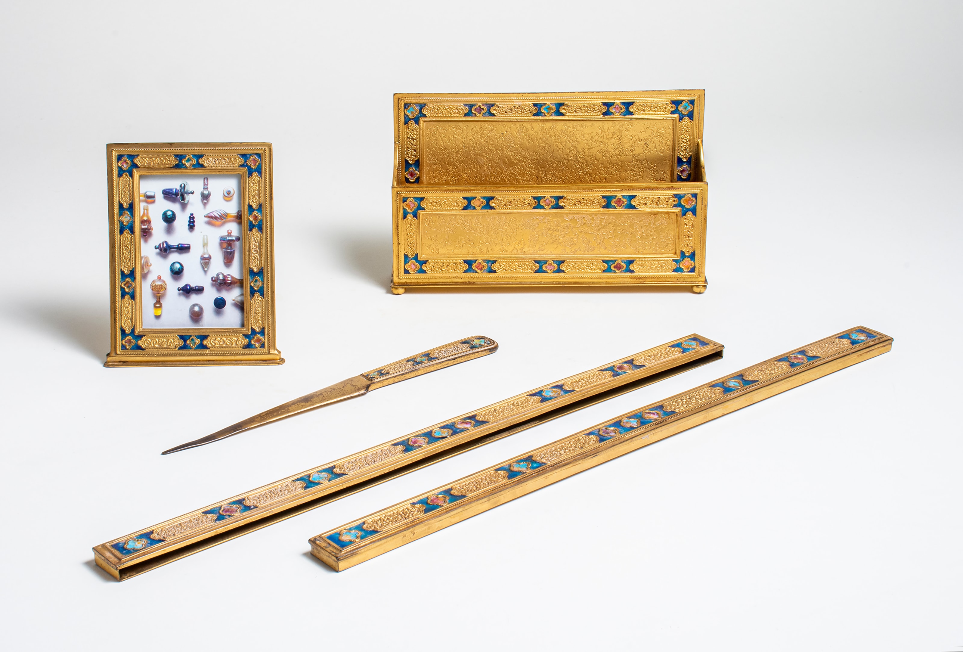 a gilt bronze desk set by louis c. tiffany furnaces inc. dating from the 1920s, the borders decorated with motif of inset blue enamel