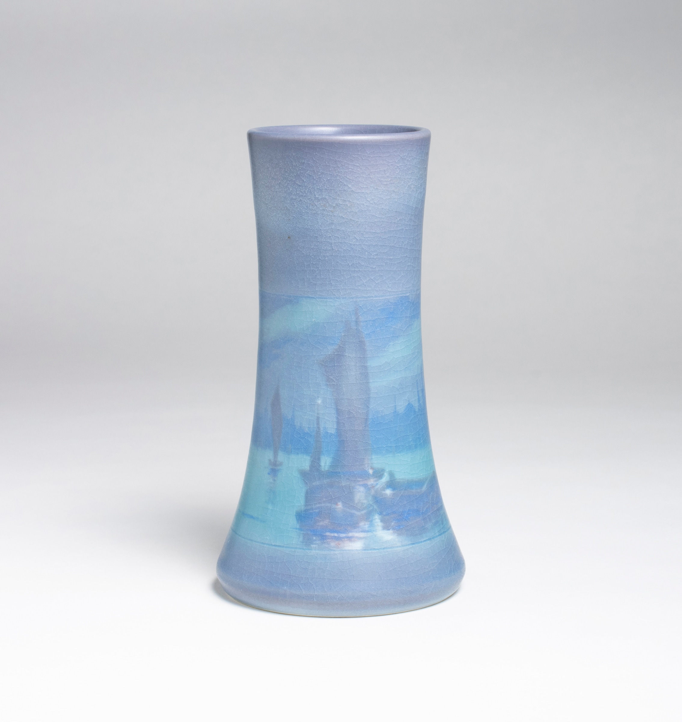 vase in scenic vellum by rookwood pottery designed by fred rothenbusch, waisted cylinder form in pastel lavenders and blues depicting an evening harbor scene at twilight
