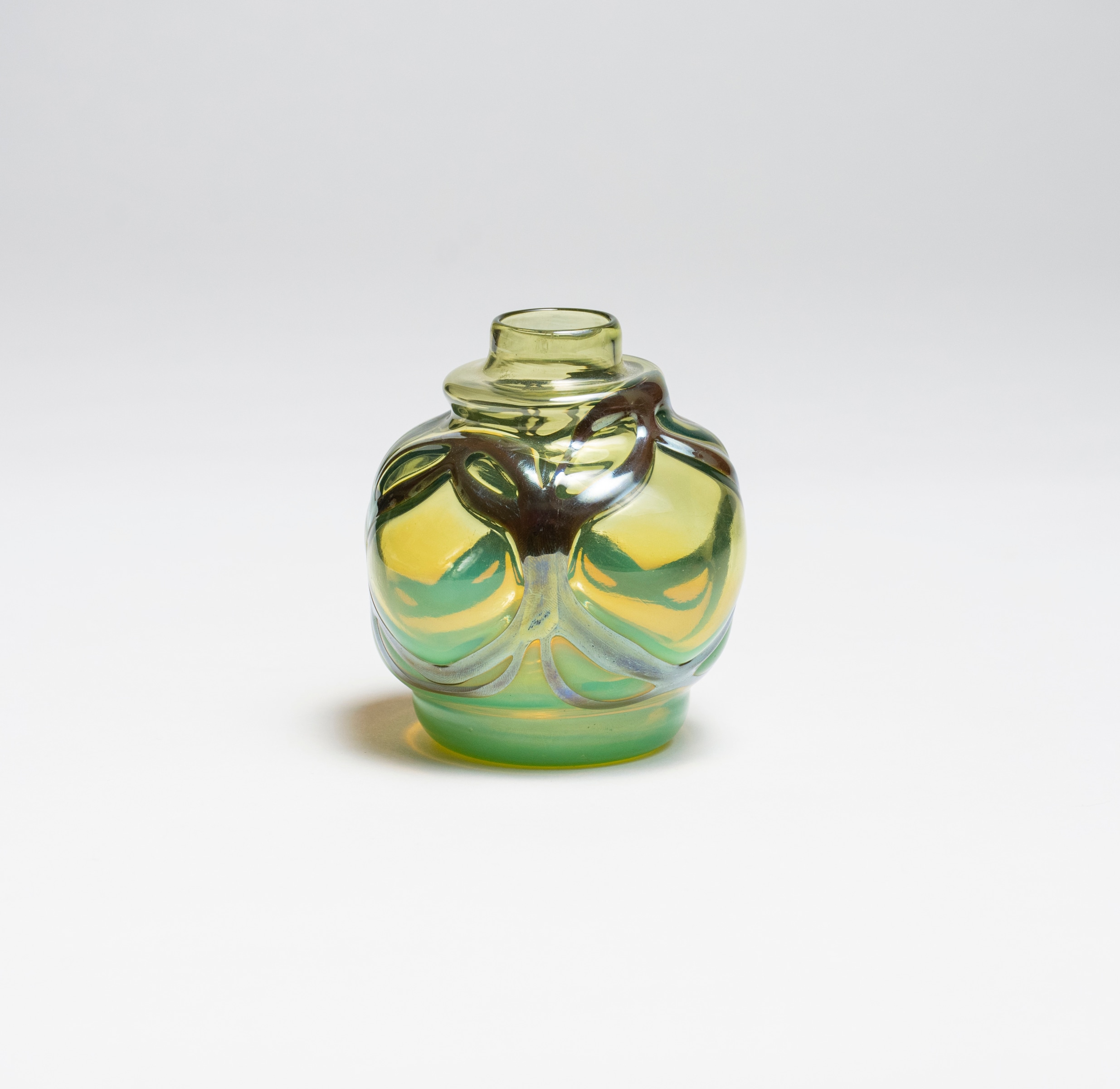 an early piece of blown tiffany favrile glass, a smallish cabinet vase in a slightly neon yellow-ish green tone, with a different layer of silvery glass applied to the surface as if metalwork.