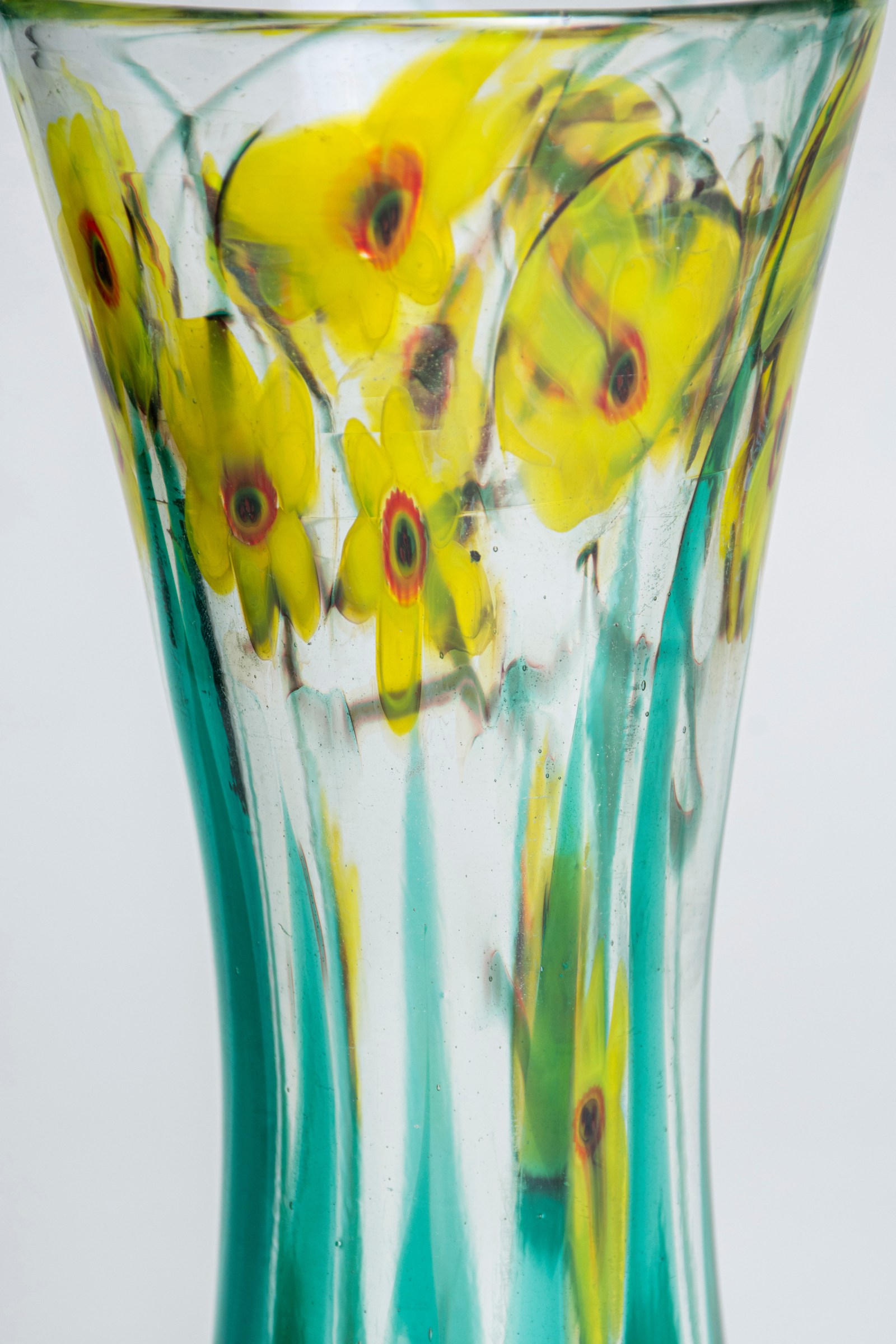 An extreme close up of the tiffany favrile glass floral paperweight vase showcasing the technique used to create the flowers, called millefiori, in which thin tubes of glass are formed together to create an image.