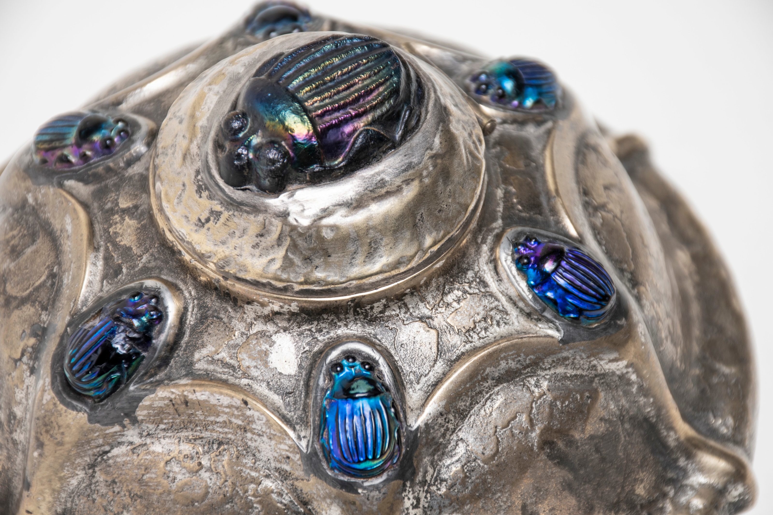 the irregular sterling silver surface and inset rainbow iridescent tiffany favrile glass scarabs on a rare tiffany studios inkwell