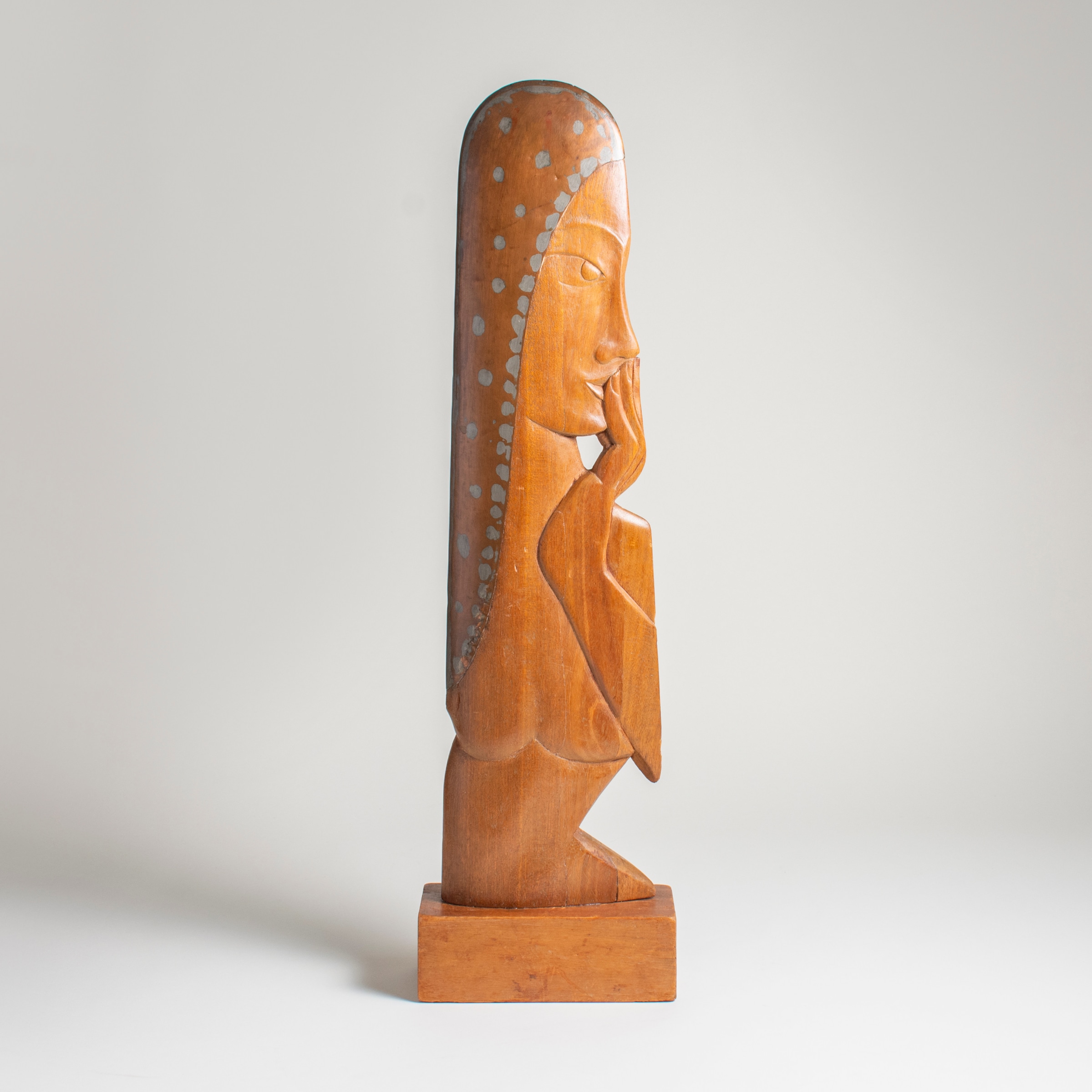 an unusual midcentury sculpture titled anxiety, of a woman with stylized features carved out of wood, holding her hand up to her mouth, her &quot;hair&quot; formed by a found plane propeller - the metal contrasting with the carved wood.
