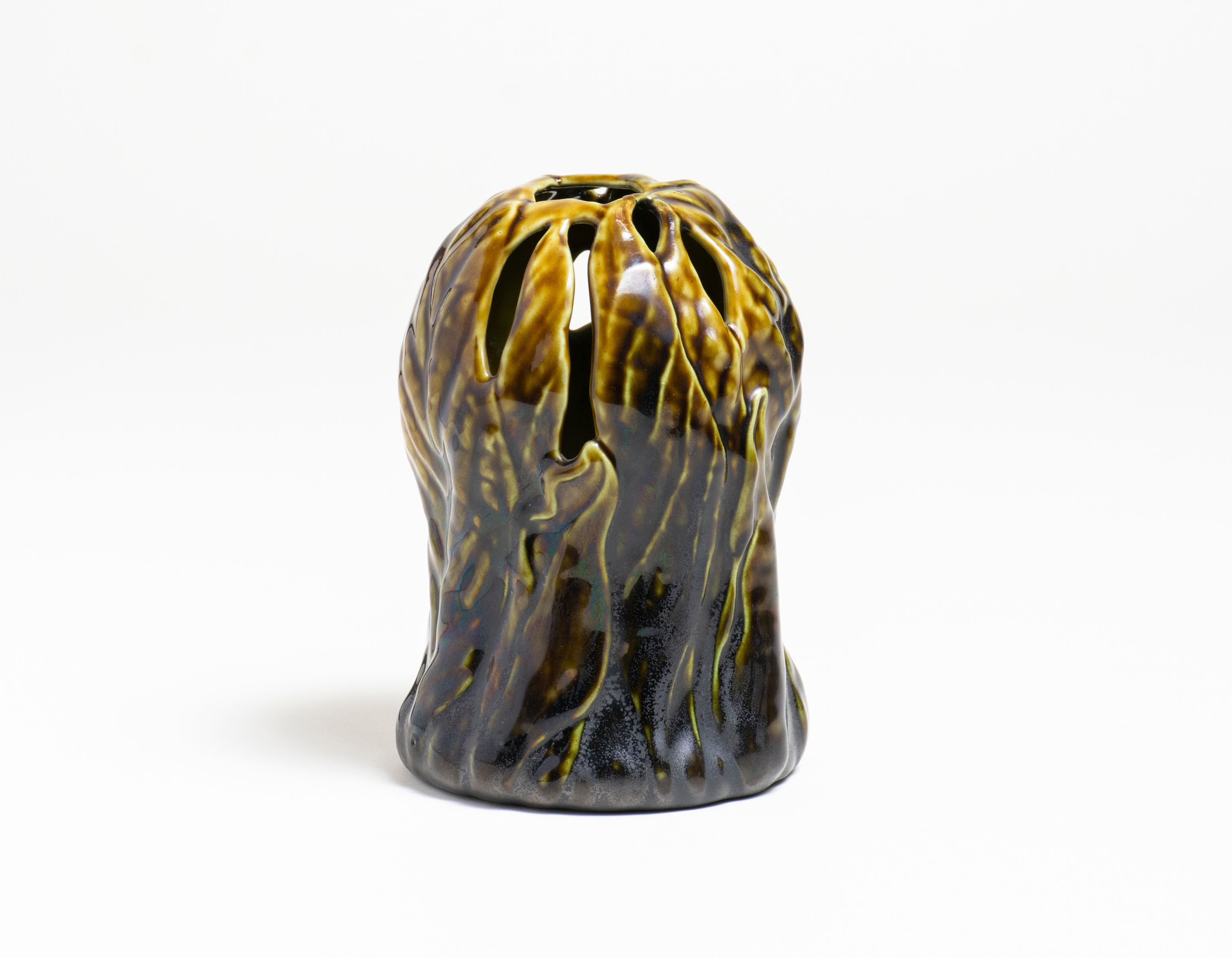 a rare tiffany pottery vase, the vessel taking the form of the skunk cabbage plants, the body of the vase formed by overlapping leaves sprouting from the &quot;earth&quot; at the base, with openings at the top