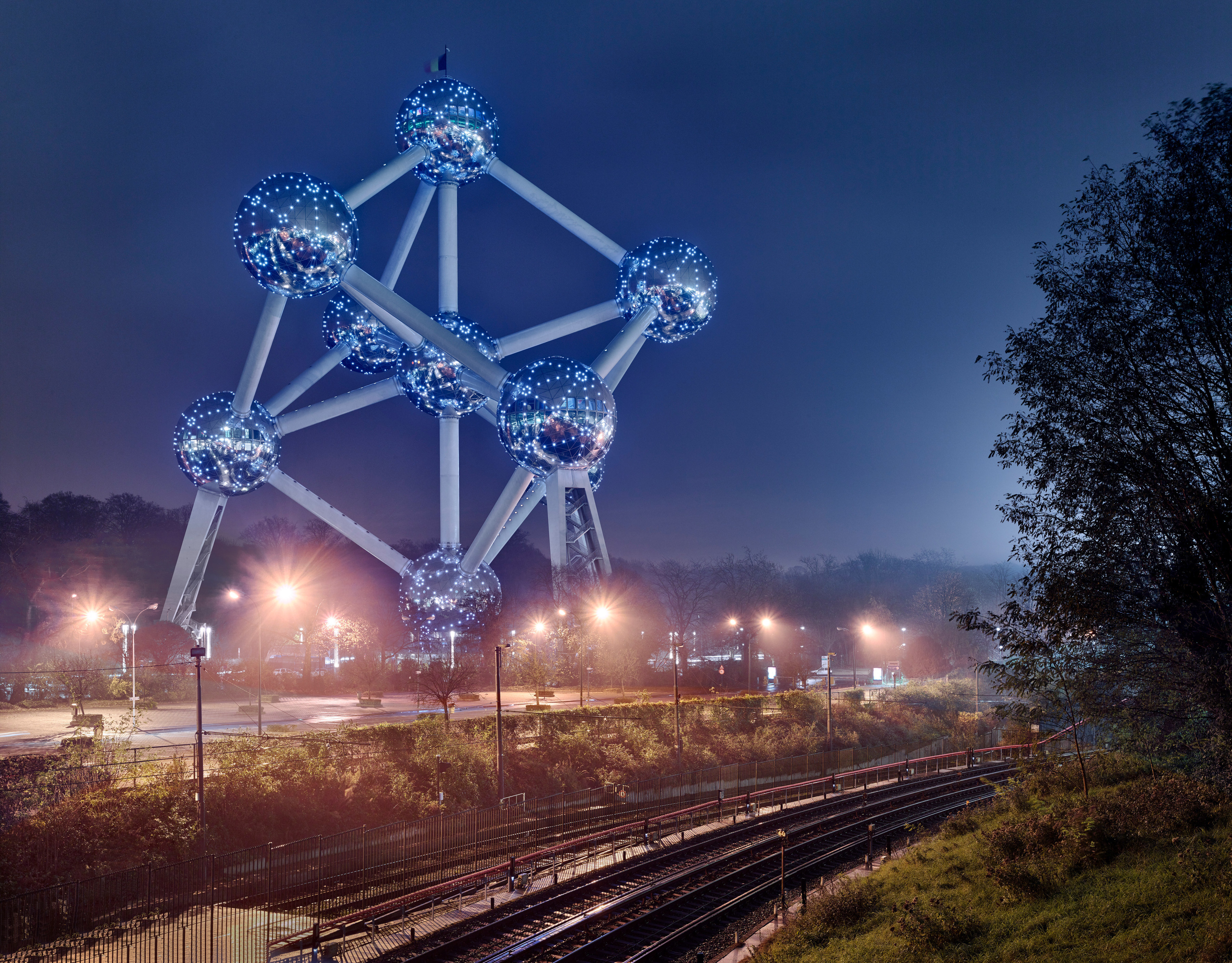 Large sculpture of an atom in Brussels, overlooking traintracks
