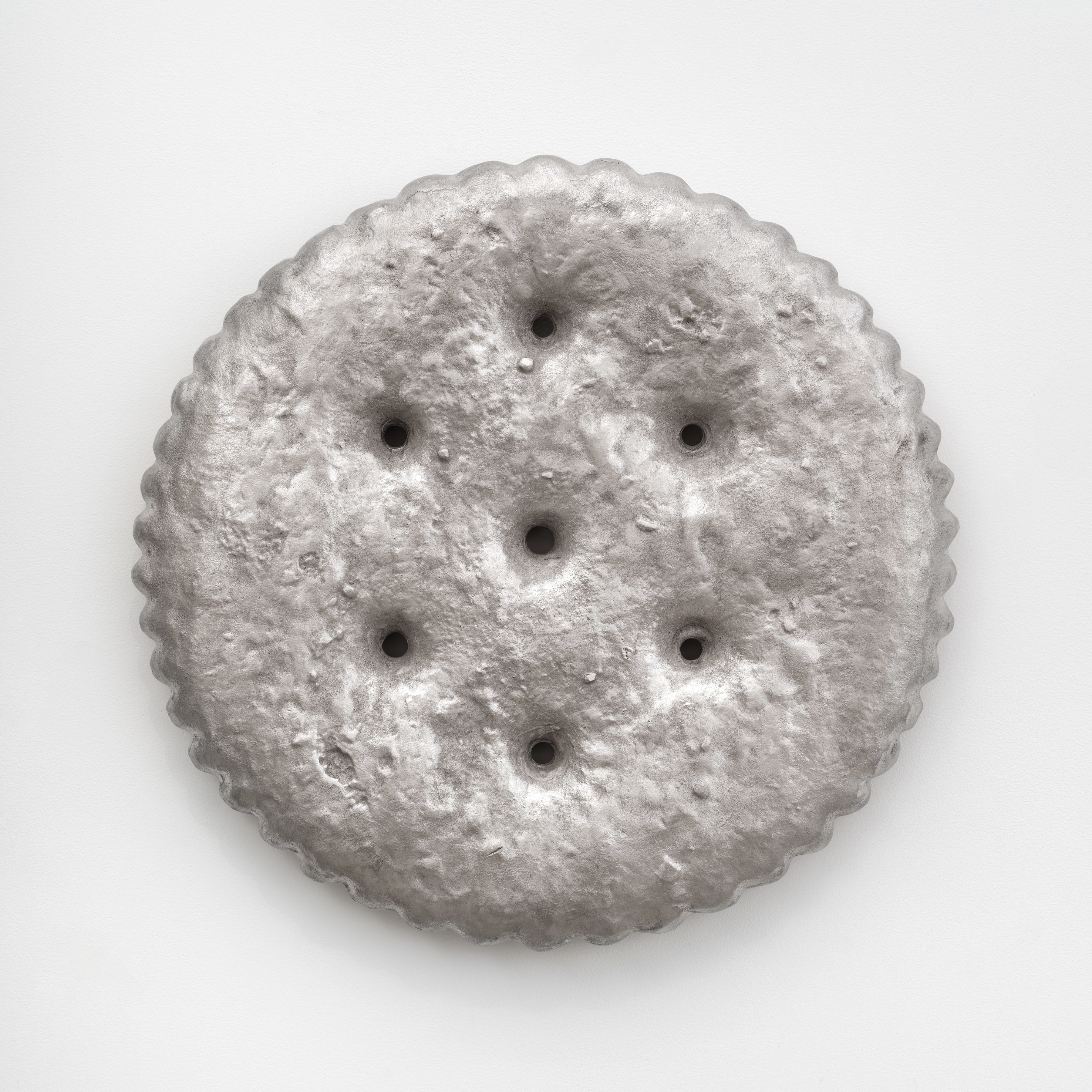 A large aluminum cast ritz cracker mounted to the wall
