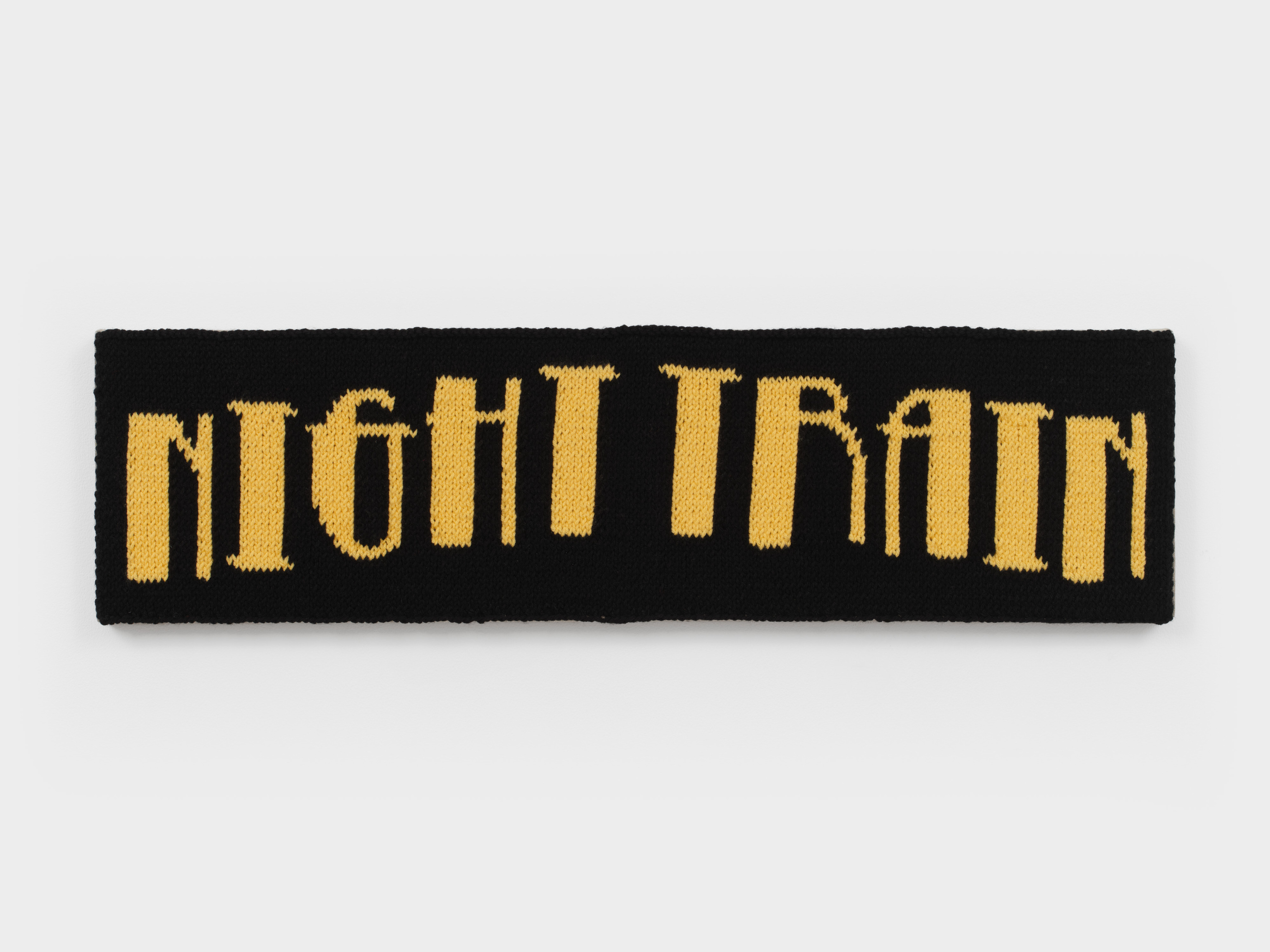 A knit artwork depicting the words "Night Train" in yellow yarn against a black background, sewn into linen and stretched.