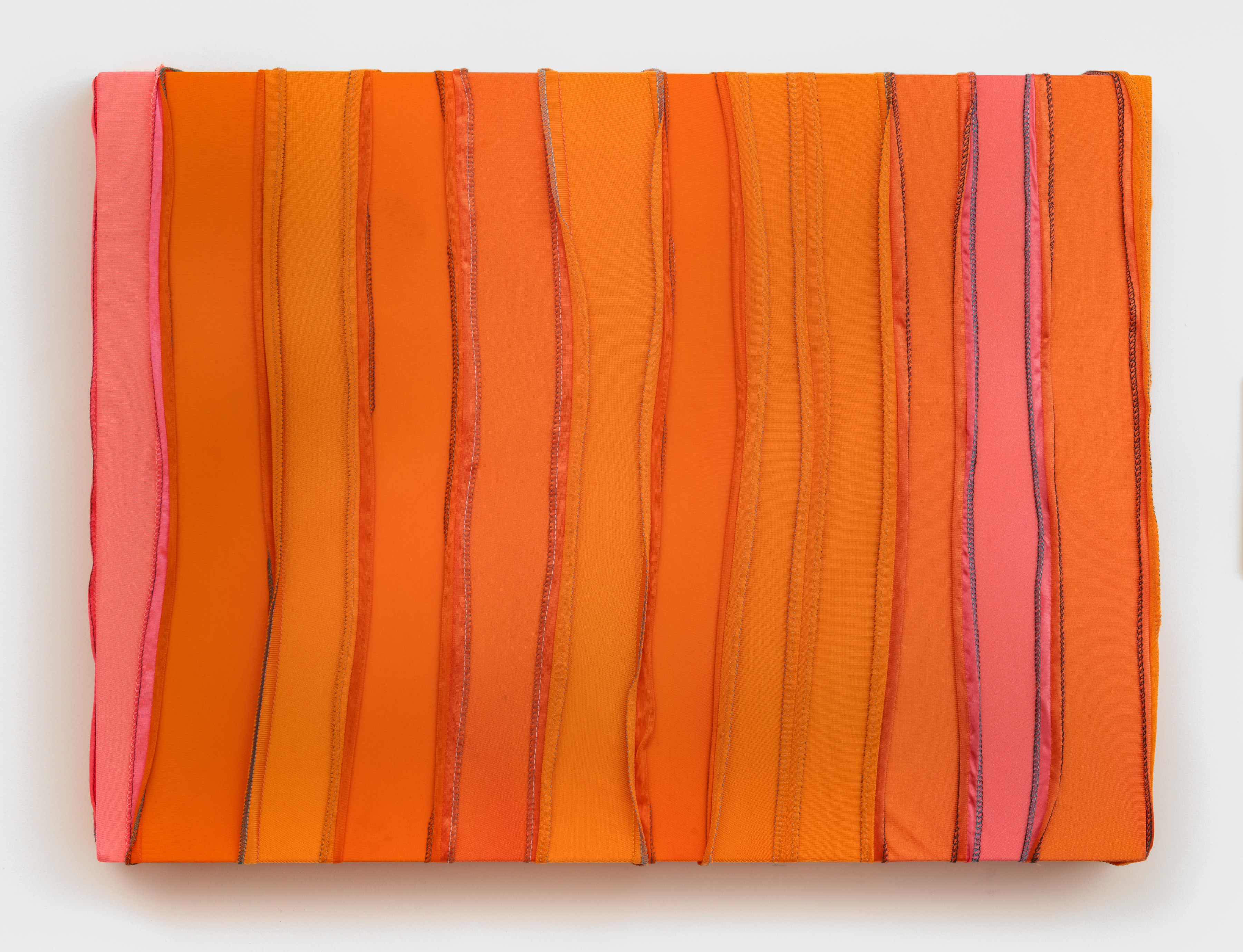 A rectangular painting made from orange and coral durags sewn into vertical stripes. 