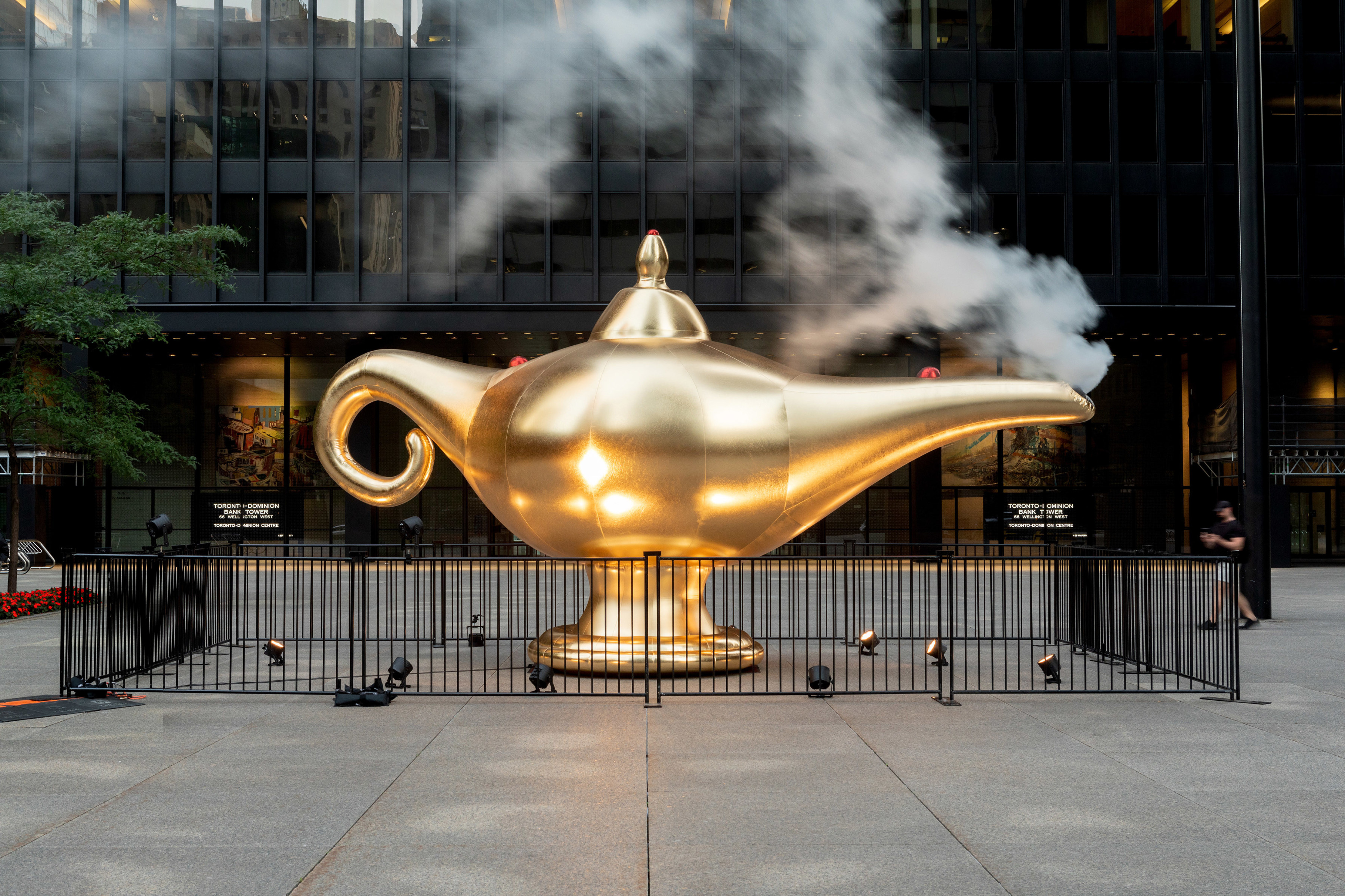 A large inflatable sculpture of a golden smoking lamp installed outdoors.