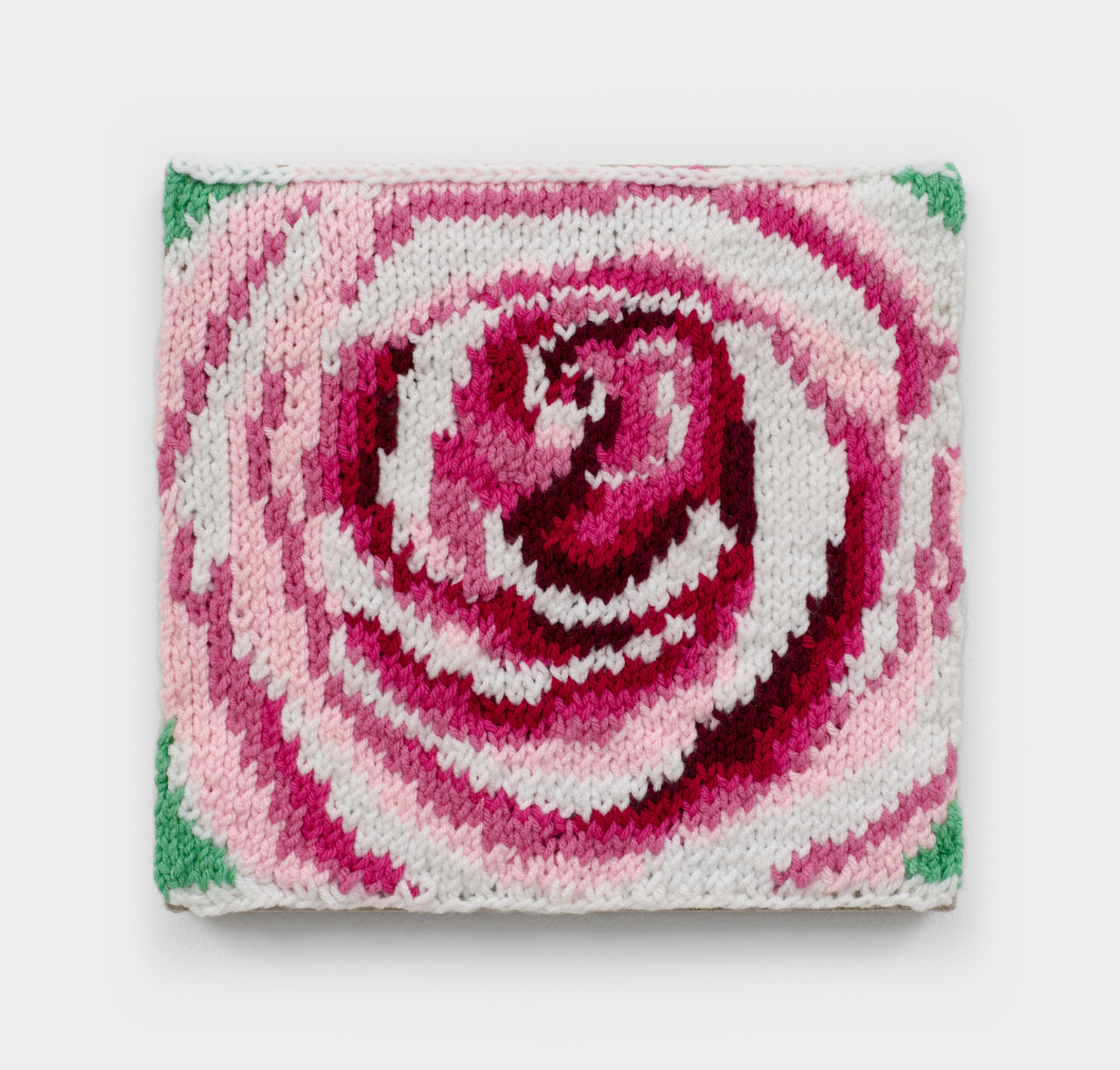 A knit artwork depicting a pink rose with green leaves, sewn into linen and stretched.