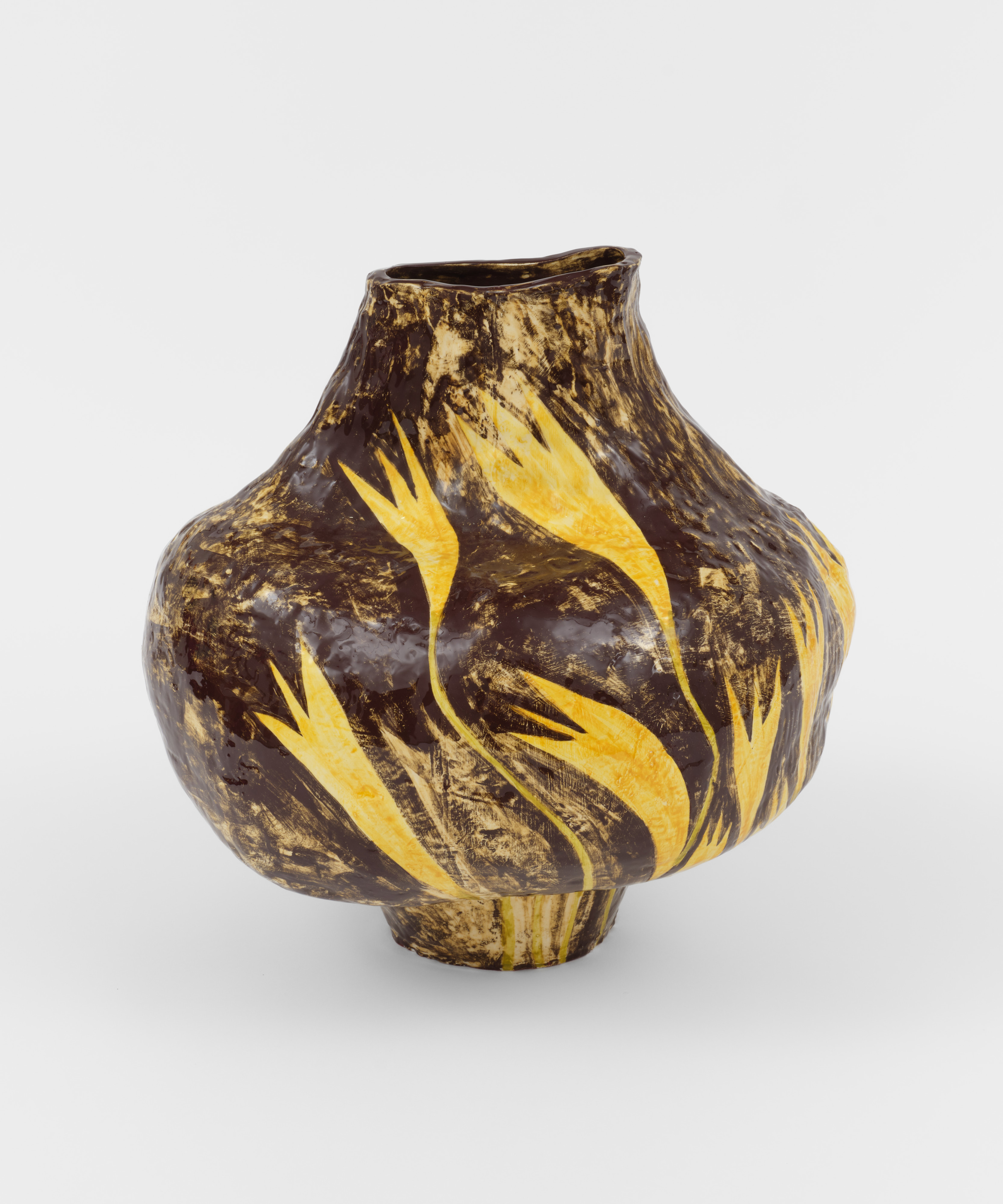 A large round ceramic brown painted vase with yellow flowers. 