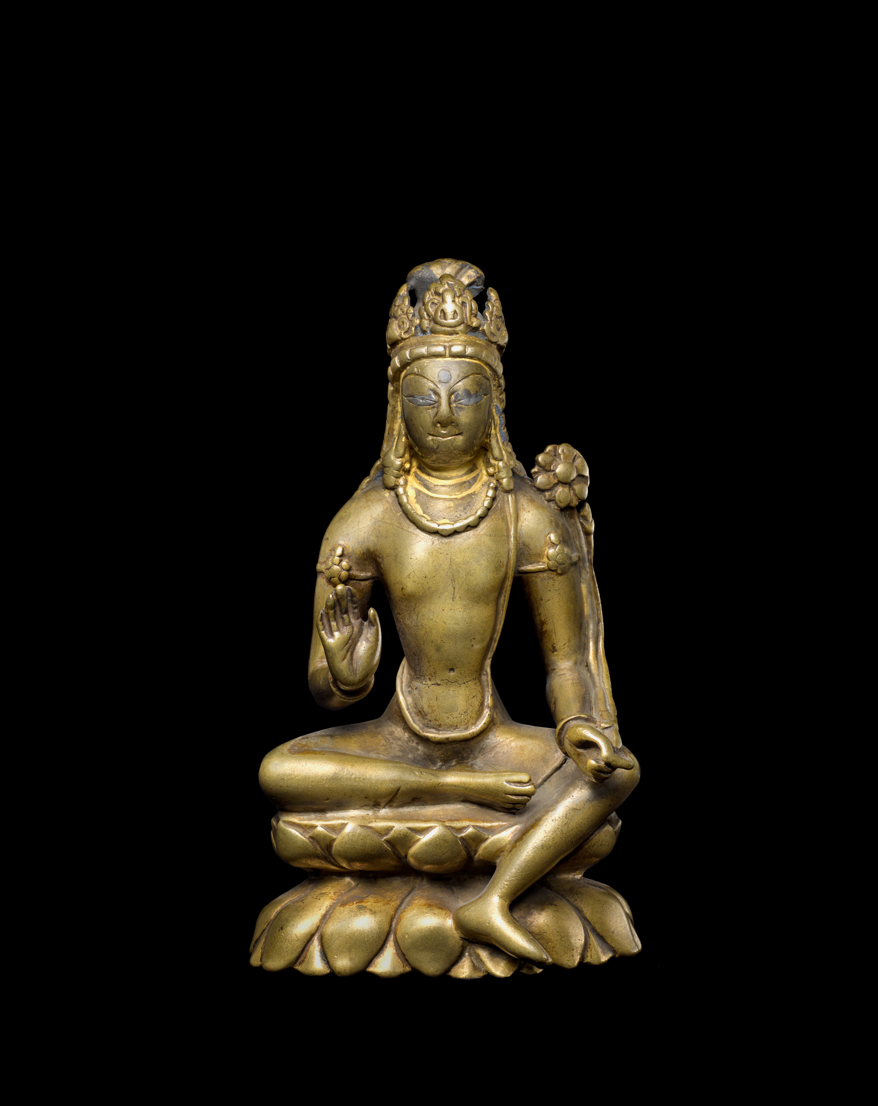 This elegant sculpture depicts Avalokiteshvara Padmapani seated at ease with his left leg reaching over his pedestal 