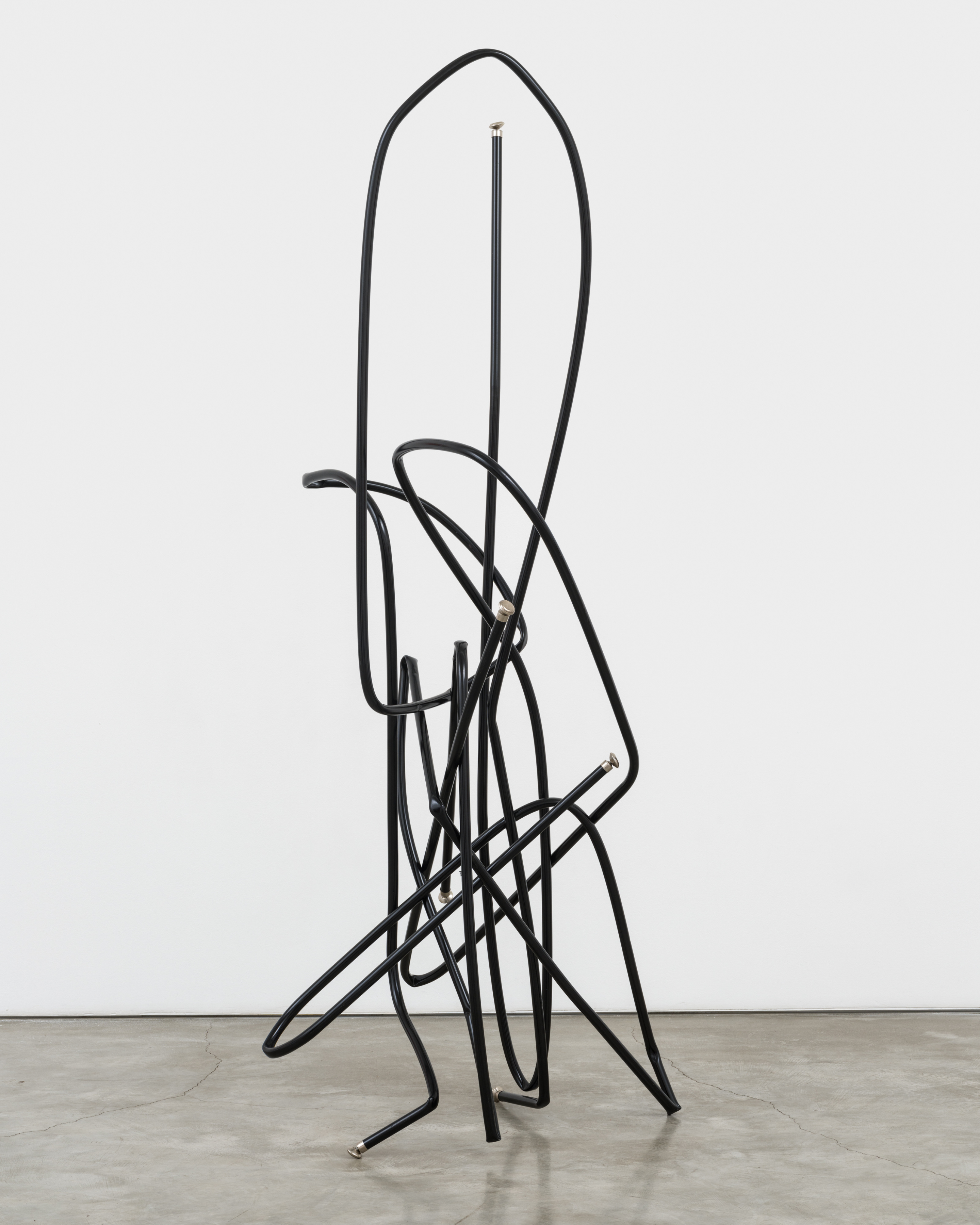 A freestanding sculpture by Josh Callaghan of black metal tubing arched and interlocking.