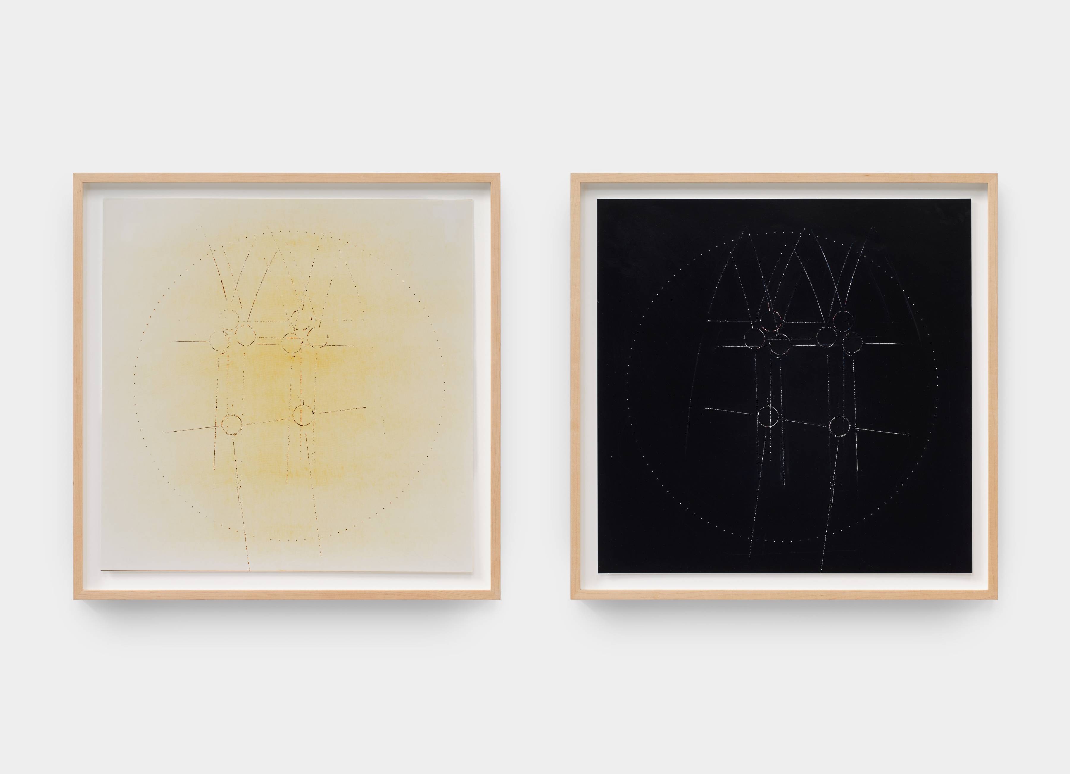 A diptych by Laura Howard Parker of two inverted framed pieces of paper with rounded symbols etched into the page.