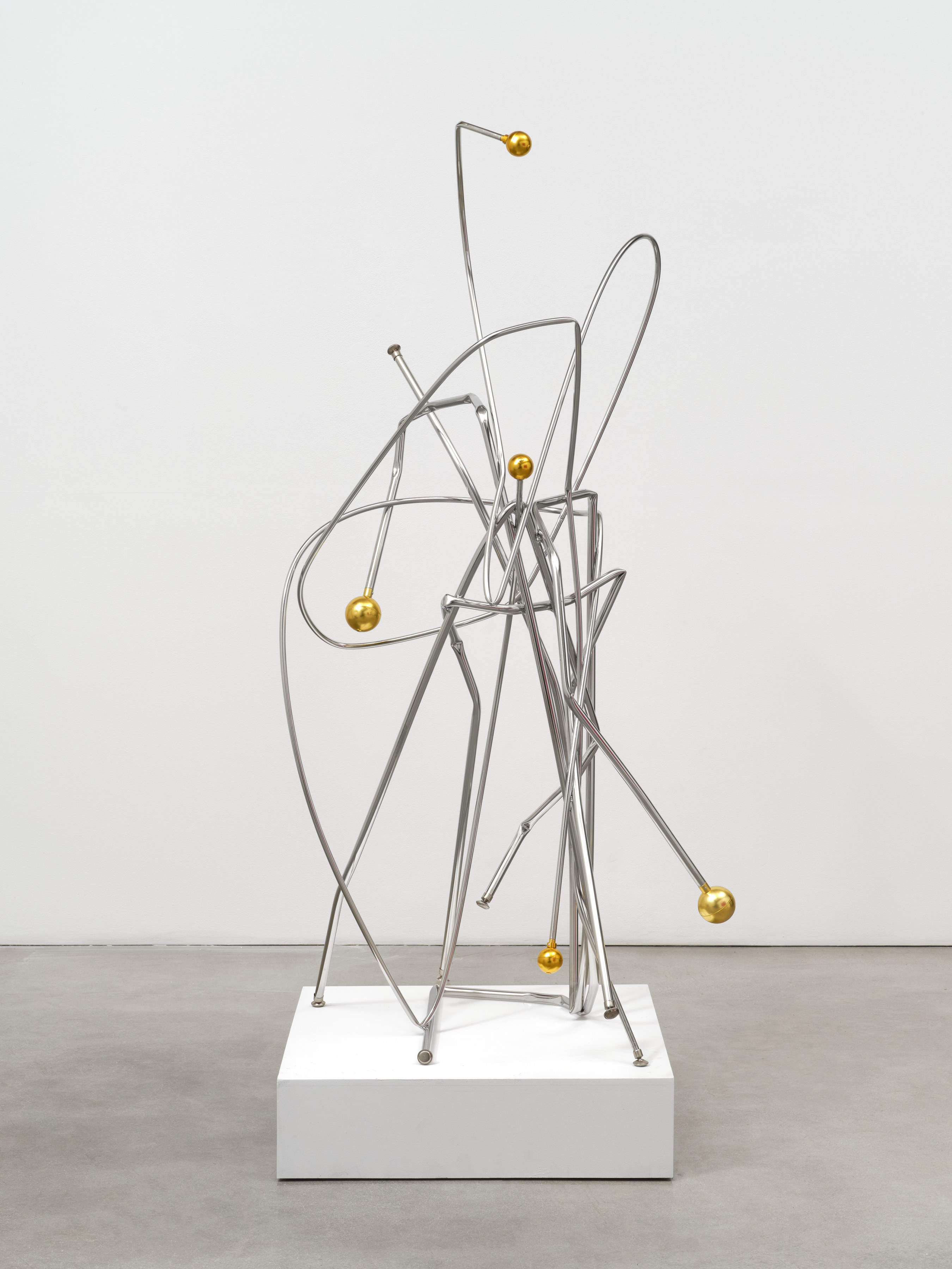 A steel sculpture by Josh Callaghan of twisted silver bars affixed with gold metal balls at the ends. 