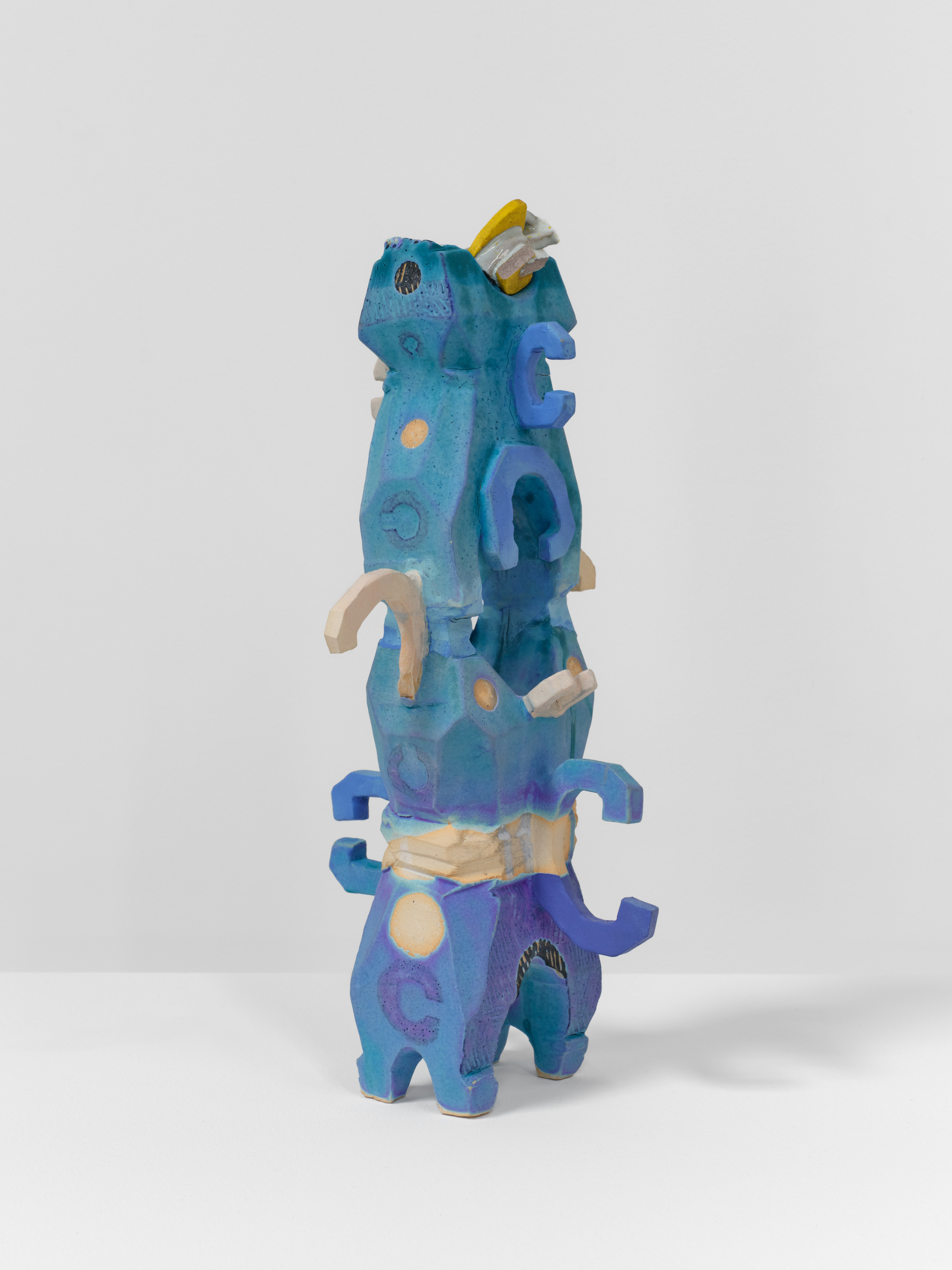 An abstract ceramic sculpture by Brad Eberhard of a blue tower like shape.