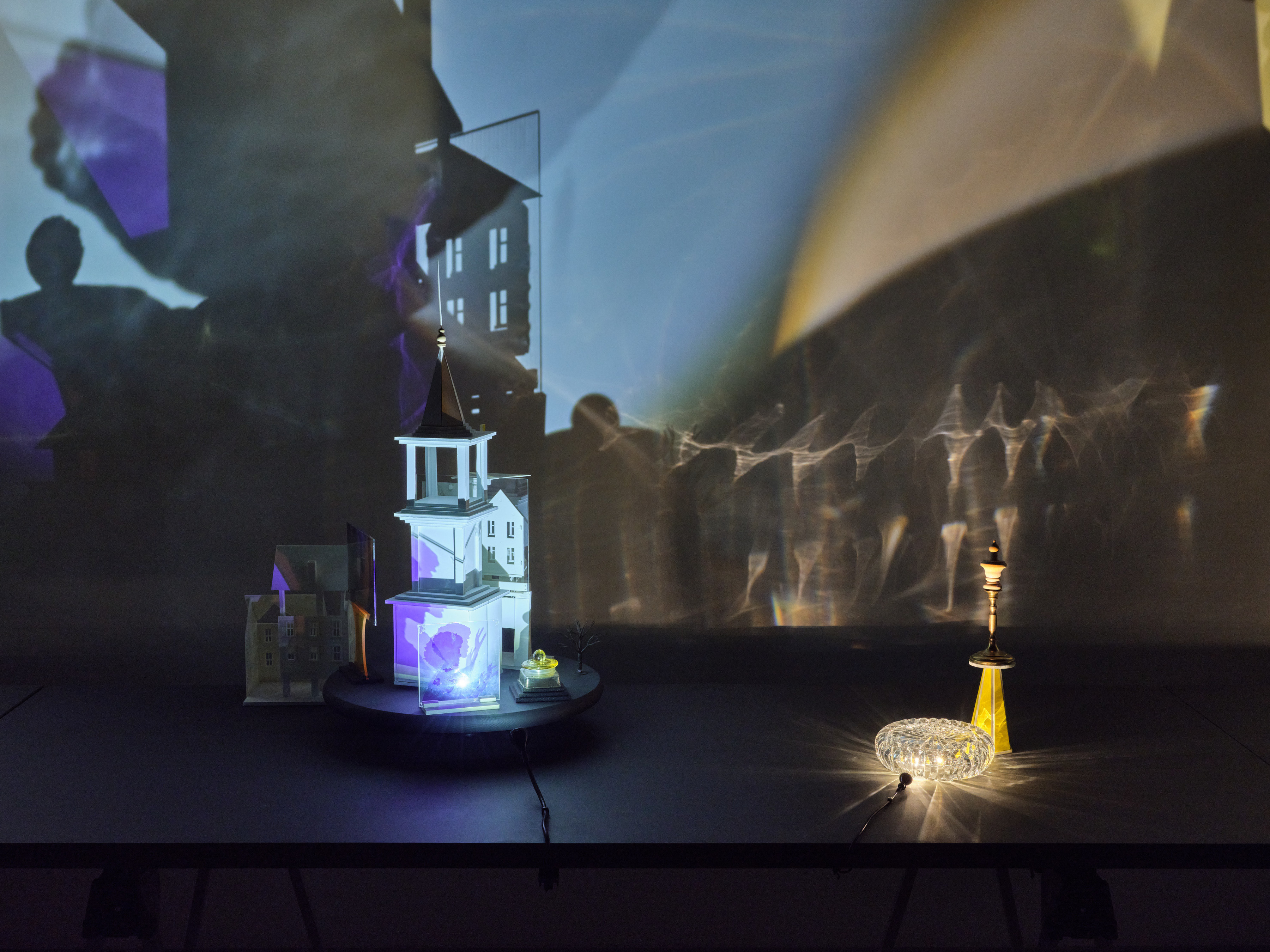 Two table top sculptures comprised of a miniature steeple topped building, colored plexiglass, a small yellow steeple and an overturned crystal bowl. 