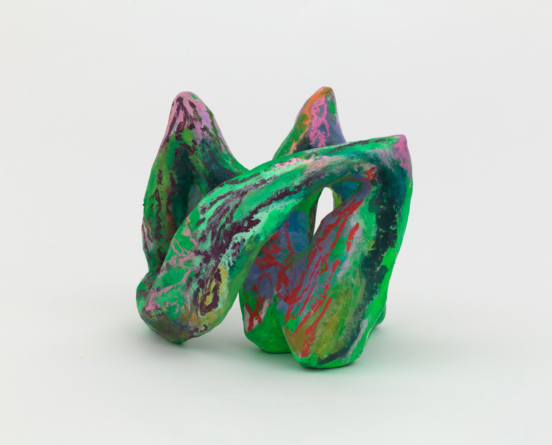 A small green abstract sculpture made from wood and papier maché of three connected pointed forms. 