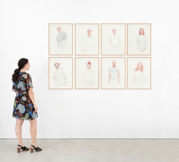 woman observing a series of portrait drawings