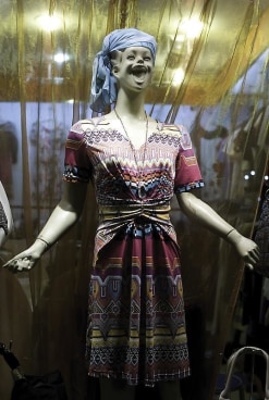 store mannequin with a very large smile dressed in a colorful dress