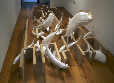 sculpture of several fish jumping around through a maze