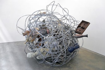A mixed media collage of sculptures strung together by razor wire.