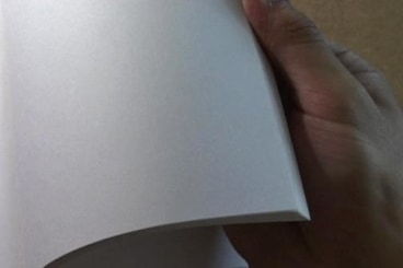 a hand flipping through blank pages of a book