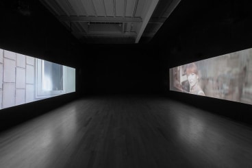dark gallery with two video projections on opposite sides