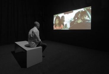 person sitting on a bench looking at a video projection