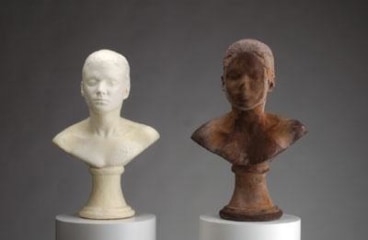 two busts of a woman, one white made of soap and the other brown made of chocolate