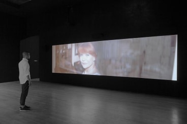dark gallery space with a video projection