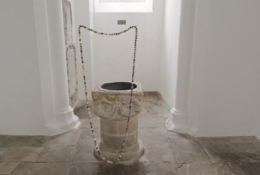 necklace with brown, beige, and white beads suspended in mid-air