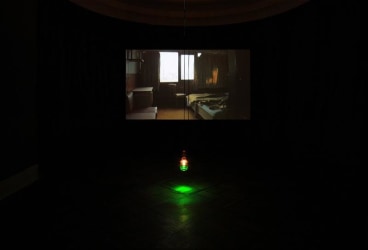 green lightbulb hanging in front of a video screening