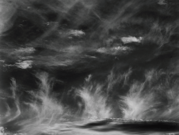 A blurry image of plumes of smoke rising from the ground in a black and white photo