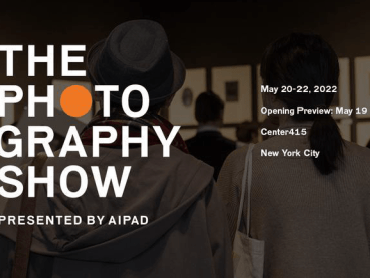 The logo of the photography show and the dates and information overlaid on a photograph of two people standing and photographed from behind.