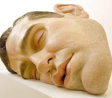 Giant realistic head of a man laying on its side