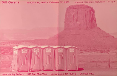 pink poster with portapotties in front of mountain landscape