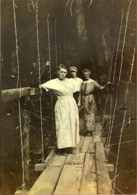 Old photo of three woman standing on wooden walkway