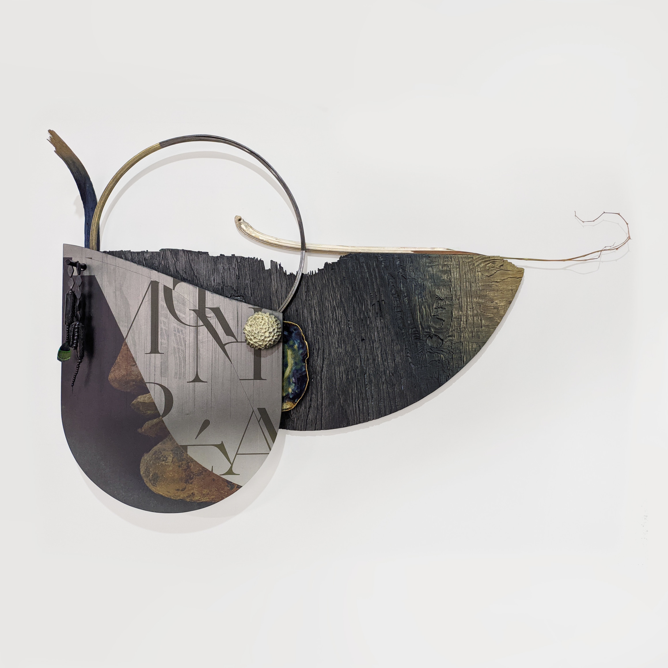 Omar Barquet, 2nd Alchemist (for H. Laurens), 2022. Digital print on enameled glass, fragments of enameled sandblasted wood, rocking chair, embroidery hoop, carved furniture and tree branch, enameled ceramic plate and coral stone, carved wood and black clay necklace with peacock feather, 37 3/8 x 59 x 10 1/4 inches.