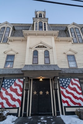 Star of Hope Lodge in Vinalhaven, Maine. Stylized painted American flags appear over the windows on each side of the doorway.