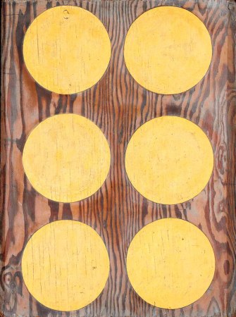 Three horizontal rows of two golden orbs on a plywood background