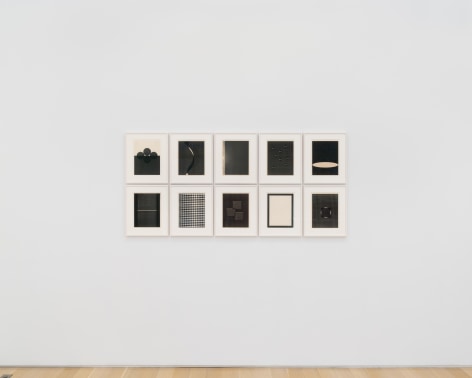 installation view of multiple works on paper in a white room