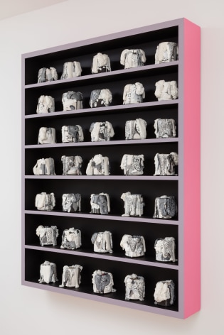 cabinet with a bunch of little ceramic pots in it