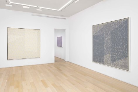 installation view of paintings in a white room